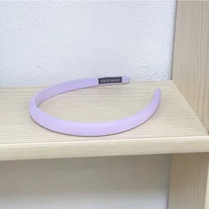Light purple fabric hair hoop detail showing neat handmade stitching and texture close-up.