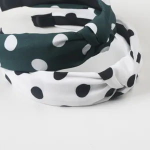 Vue rapprochee detaillee du headband en tissu noue avec un motif a pois classique et elegant.
