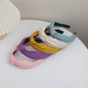 Solid color knotted headband for women, minimalist wide hair hoop, stylish daily hair accessory.
