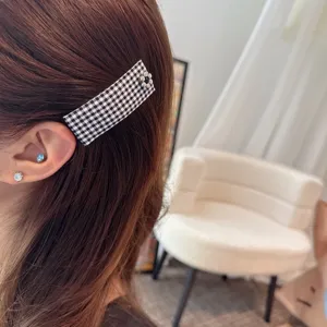 Checkered fabric BB hair clip detail, retro black and white plaid design with metal flower.