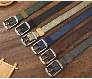 Detailed view of woven canvas belt with metal pin buckle in various colors, neatly arranged.
