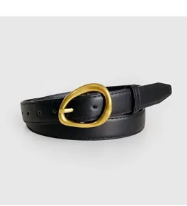 Black leather belt for women with unique gold buckle. Detailed view of the stylish fashion accessory.