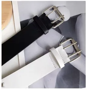 Women's double prong buckle leather belt detail showing black and white options clearly.