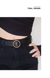 Retro black leather belt detail shot with antique brass twisted round metal buckle accessory.