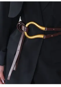 Primo piano dettagliato di un'elegante cintura in pelle marrone con grande fibbia.