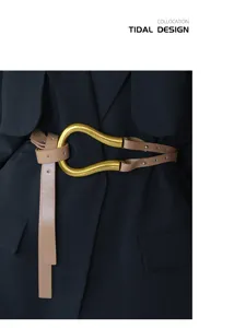 Dettaglio di un'elegante cintura in pelle larga con grande fibbia a ferro di cavallo per cappotti.
