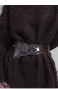Punk style wide leather belt detail shot featuring metallic studs and ring buckle design.