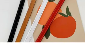 Detailed close-up view of fashionable thin leather belts in multiple classic colors.