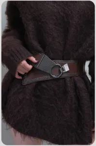 Detail shot of women wide punk studded belt, asymmetrical design, versatile dress cincher.
