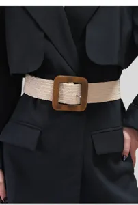 Detail shot of a women wide straw woven elastic waist belt with a dark wooden square buckle.