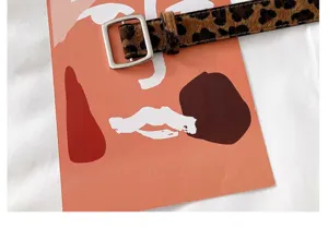 Gros-plan sur la ceinture léopard pour femme avec boucle carrée argentée élégante.