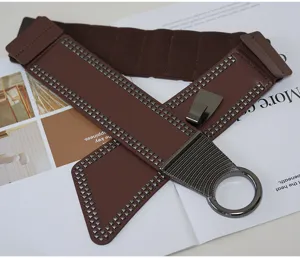 Detailed view of a wide punk elastic waist belt for women with metal studs and ring.