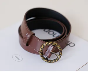 Retro brown women's leather belt with vintage round metal buckle for casual jeans wear.