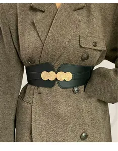 Detail shot of women wide elastic waist belt with metal round buckle, stylish coat accessory.