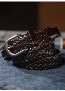 Close-up detail of dark brown woven leather belt with vintage metal buckle, premium texture.