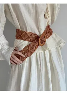 Bohemian style hand-woven brown wax rope belt detail, featuring a natural wooden ring buckle.