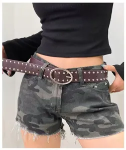 Vue détaillée de la ceinture en cuir cloutée style punk Y2K avec boucle ovale en métal.