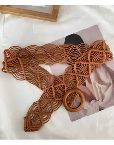 Close-up detail of bohemian handmade woven rope belt with wooden ring buckle for dress decoration.