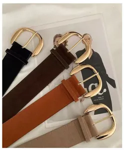 Close up view of vintage suede wide belts with shiny metallic buckles and textures.