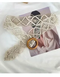 Close-up detail of bohemian handmade woven rope belt with stylish wooden ring buckle.