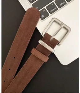 Brown vintage style suede belt close-up, featuring antique silver metal buckle and loop.