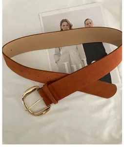 Detailed shot of a vintage brown suede belt with a sleek gold buckle, perfect for stylish looks.