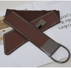 Detailed close-up shot of the wide brown elastic waist belt featuring metal studs and ring buckle.