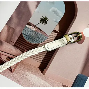 Detailaufnahme eines eleganten weißen geflochtenen Damenkleidergürtels mit Messingschnalle.