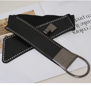 Wide elastic punk style waist belt for women, featuring metal studs and round ring buckle.