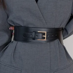 Women's wide black leather waist belt for coat and blazer, vintage minimalist style.