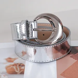 Silver shiny leather belt for women with unique crescent moon buckle decorative accessory.