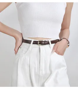 Dettaglio cintura sottile in pelle marrone minimalista con fibbia metallica elegante per outfit chic.