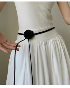 Fina correa de cuero minimalista con elegante detalle de flor negra ideal para vestidos.