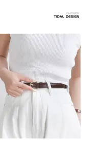Dettaglio di cintura sottile in pelle marrone con fibbia, ideale per abiti e jeans.