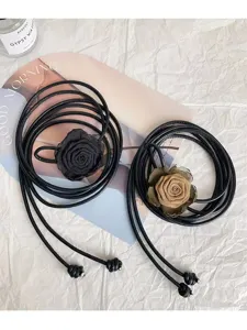 Detailed view of french style long leather cord belt with fabric rose flower, perfect dress decor.