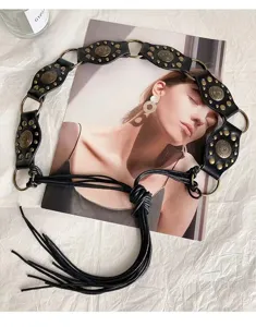 Tribal vintage punk style black faux leather waist belt with metal rings and tassel fringe.