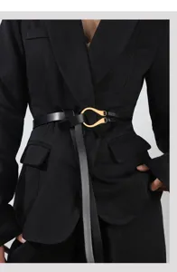 Black leather belt detail featuring a gold horseshoe buckle for stylish waist decoration