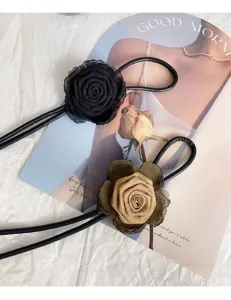 Detail shot of French style fabric rose flower thin leather waist rope for dresses.