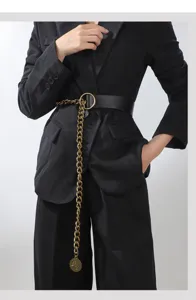 Close-up of women's wide leather belt with gold chain and coin pendant for chic vintage styles.