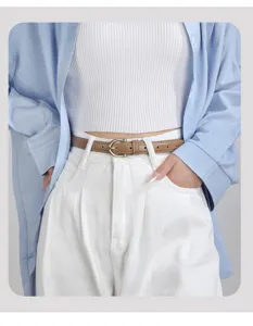 Vista di dettaglio ravvicinata della cintura sottile in pelle marrone da donna, elegante accessorio.