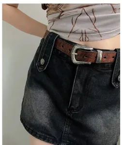 Retro ethnic style women belt with vintage metal buckle and distressed denim skirt.
