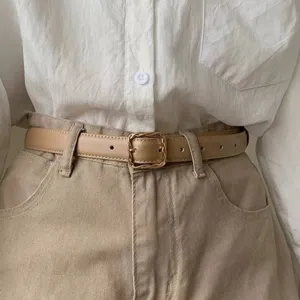 Minimalist women's leather belt with stylish gold square buckle for casual trousers.
