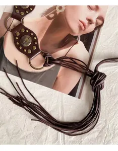 Detail view of tribal vintage punk style dark brown leather waist belt with metal studs.