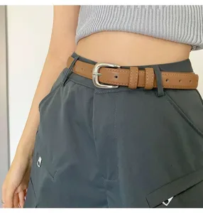 Women's brown leather belt with silver pin buckle, versatile accessory for jeans and dresses.