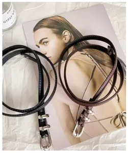 Close-up of minimalist thin leather belts with silver metal buckles, perfect for vintage daily wear.