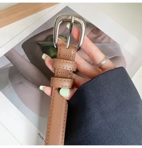 Brown leather belt detail featuring metal buckle and double loop design for women.
