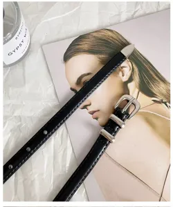 Detailed shot of a sleek black thin belt showcasing its fine metal buckle and slim strap.