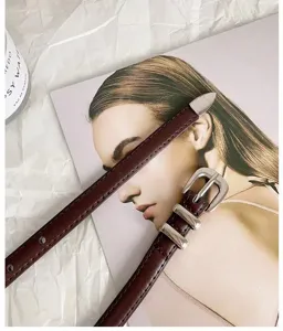 Dark red thin leather belt detail, vintage metal buckle design, elegant women accessory for jeans.