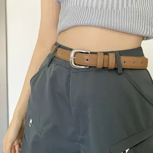 Women brown leather belt with silver metal buckle versatile minimalist design for jeans and trousers.