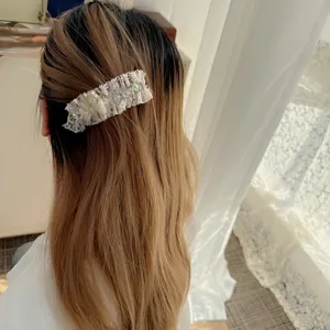 Detail view of sweet white lace rhinestone hair clip, elegant and gentle hair accessory.